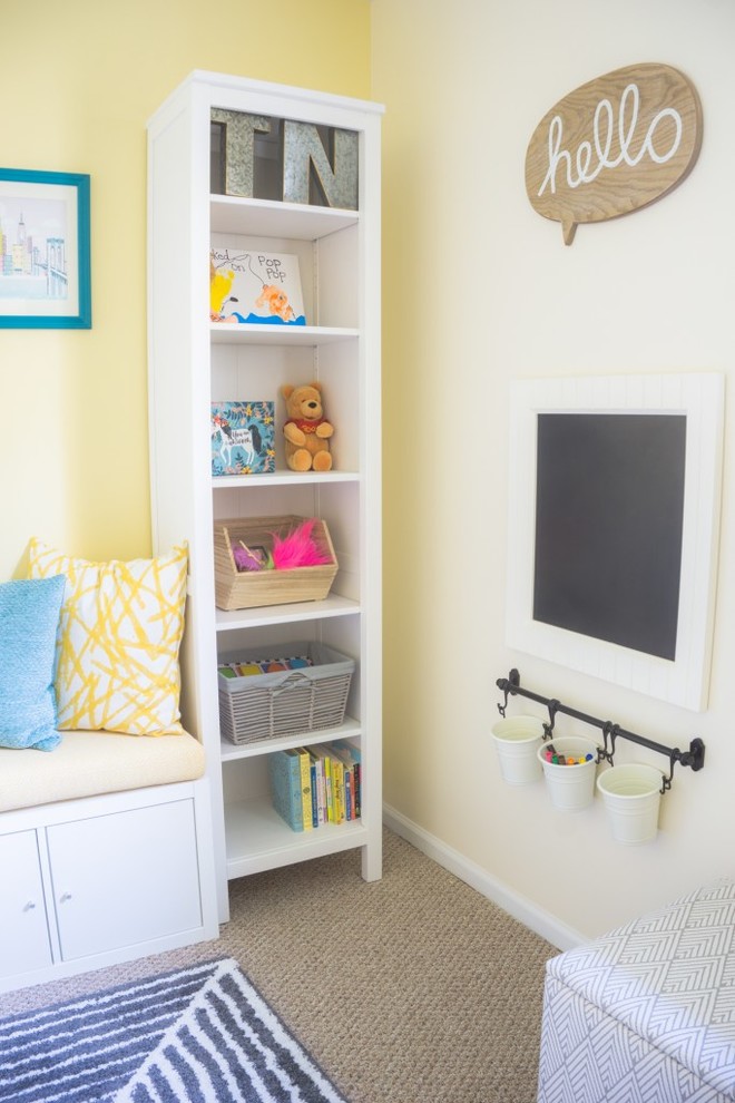Modern inredning av ett litet könsneutralt småbarnsrum kombinerat med lekrum, med gula väggar, heltäckningsmatta och beiget golv