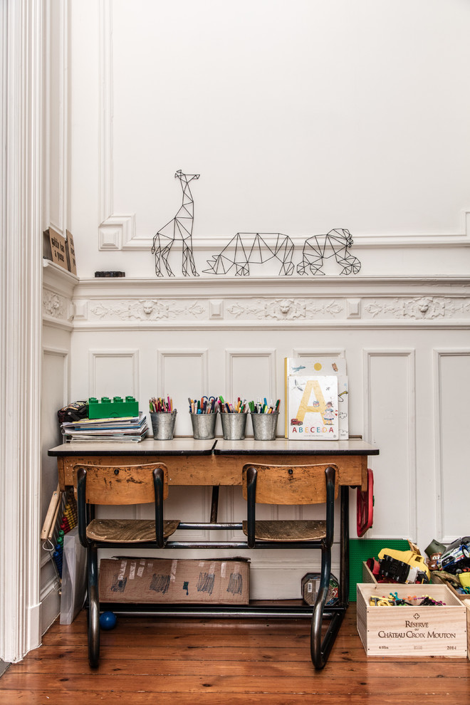 Bild på ett eklektiskt barnrum kombinerat med lekrum, med vita väggar, mellanmörkt trägolv och brunt golv