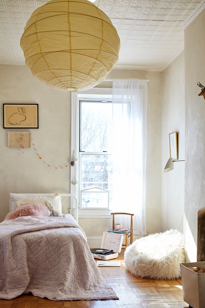 Small rural kids' bedroom in New York with brown floors, beige walls and medium hardwood flooring.