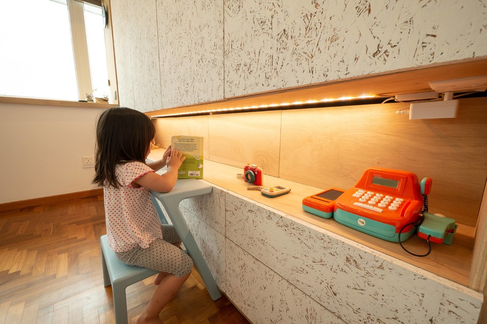 Esempio di una piccola cameretta per bambini da 1 a 3 anni contemporanea con pareti bianche, pavimento in legno massello medio e pavimento marrone