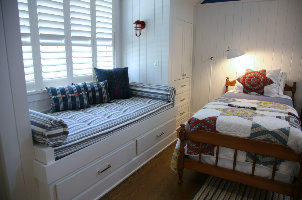 Cette photo montre une petite chambre d'enfant bord de mer en bois avec un mur bleu, un sol en bois brun, un sol marron et un plafond voûté.