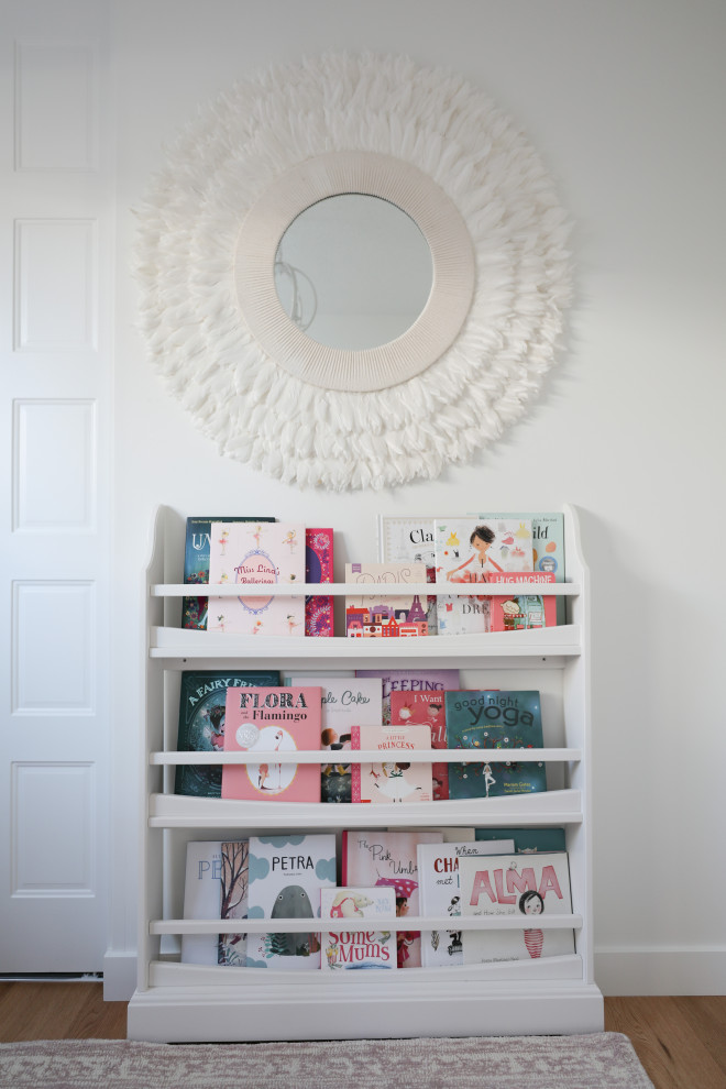 Inspiration for a small modern children’s room for girls in Calgary with white walls, light hardwood flooring and wallpapered walls.