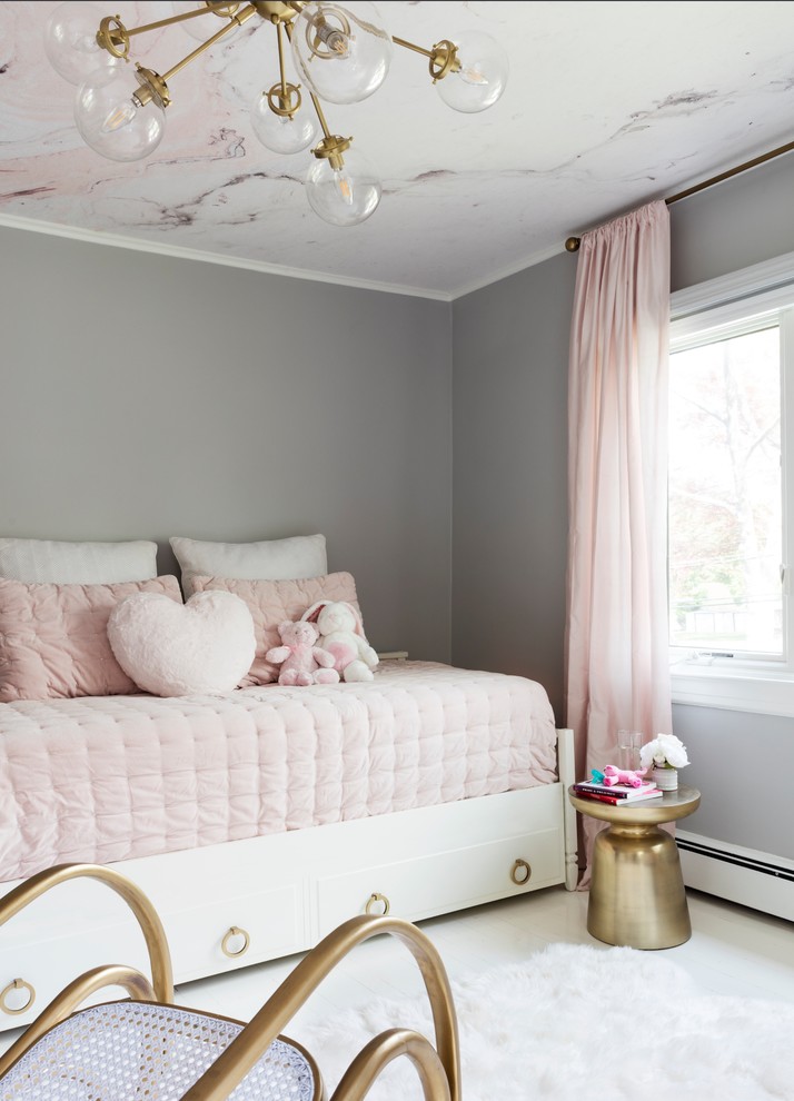 Photo of a small classic toddler’s room for girls in New York with grey walls, painted wood flooring and white floors.