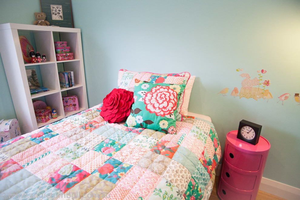 Idée de décoration pour une chambre d'enfant design de taille moyenne avec un mur bleu et un sol en bois brun.
