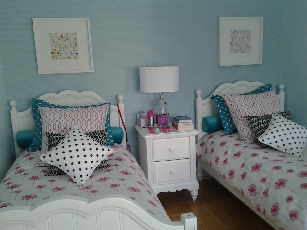 Medium sized bohemian children’s room for girls in Montreal with blue walls and medium hardwood flooring.