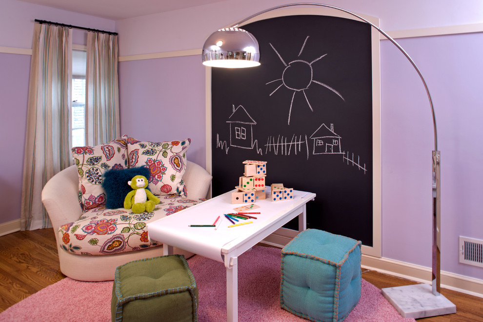 Foto på ett funkis könsneutralt barnrum kombinerat med skrivbord och för 4-10-åringar, med lila väggar och mellanmörkt trägolv