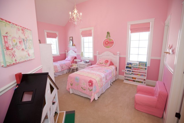 This is an example of a large country children’s room for girls in Chicago with pink walls, carpet and beige floors.
