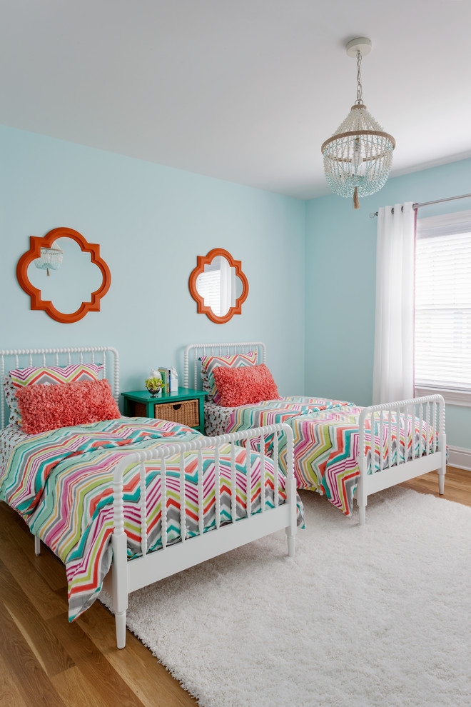 Diseño de dormitorio infantil clásico renovado con paredes azules y suelo de madera en tonos medios