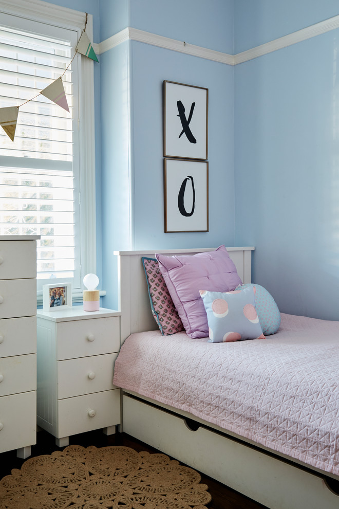 Inspiration för ett mellanstort vintage flickrum kombinerat med sovrum och för 4-10-åringar, med blå väggar, mörkt trägolv och brunt golv