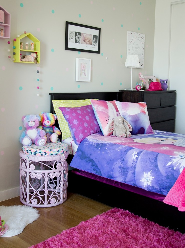 Modelo de dormitorio infantil de 1 a 3 años contemporáneo de tamaño medio con paredes beige y suelo de madera clara
