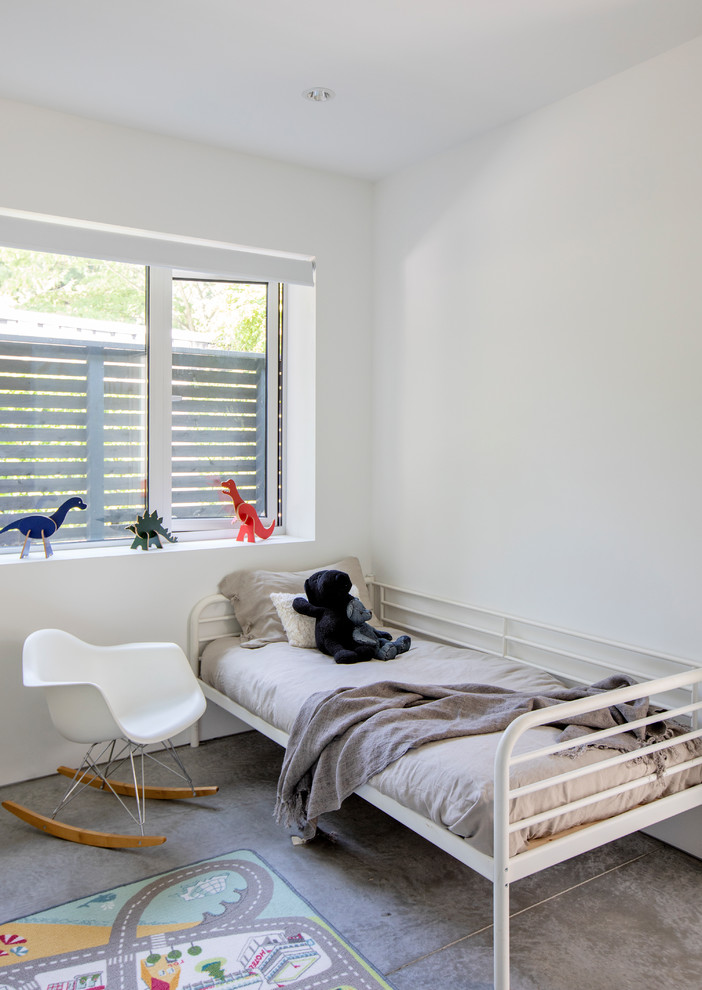 Modelo de dormitorio infantil de 4 a 10 años escandinavo de tamaño medio con paredes blancas, suelo de cemento y suelo gris