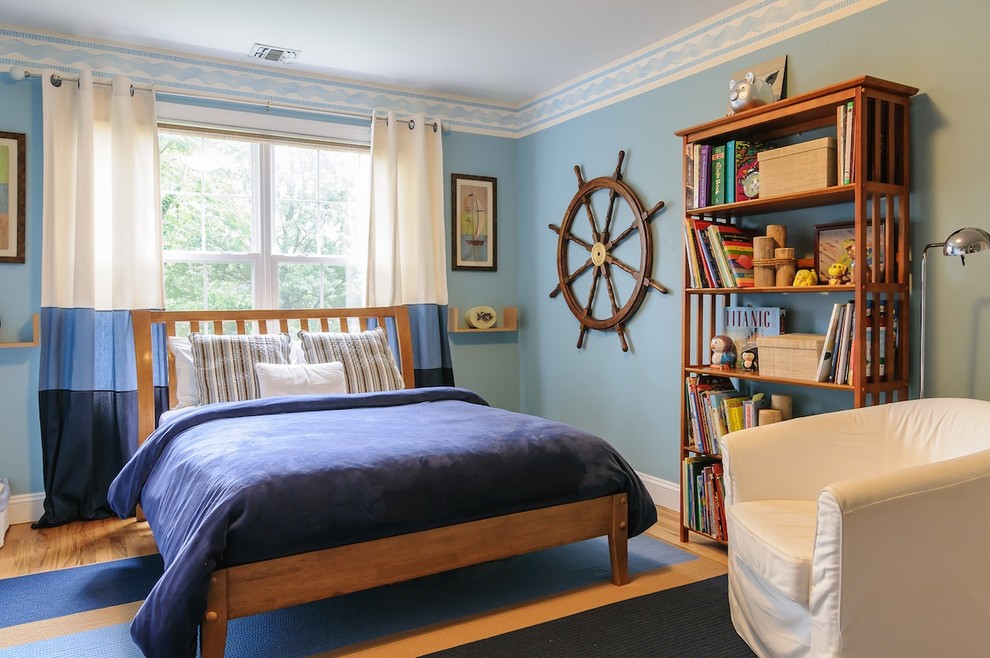 Klassisk inredning av ett pojkrum kombinerat med sovrum och för 4-10-åringar, med blå väggar och ljust trägolv