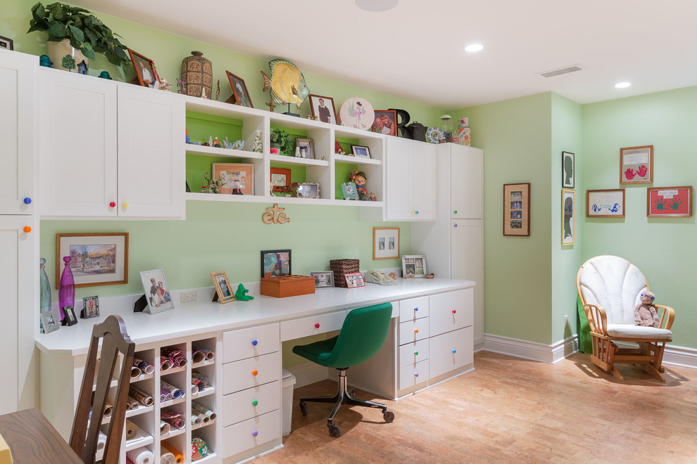 Modelo de habitación infantil unisex de 1 a 3 años clásica renovada de tamaño medio con paredes verdes, suelo de madera clara, escritorio y suelo beige