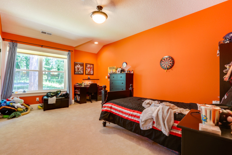 На фото: большая детская в стиле неоклассика (современная классика) с спальным местом, оранжевыми стенами, ковровым покрытием и бежевым полом для ребенка от 4 до 10 лет, мальчика