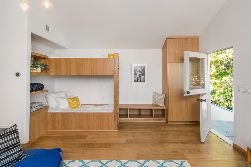 Inspiration för ett funkis könsneutralt barnrum kombinerat med sovrum och för 4-10-åringar, med vita väggar, ljust trägolv och brunt golv