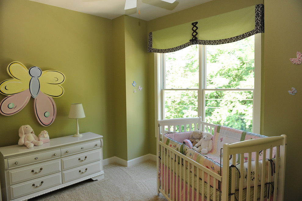 Imagen de habitación de bebé niña clásica grande con paredes verdes y moqueta