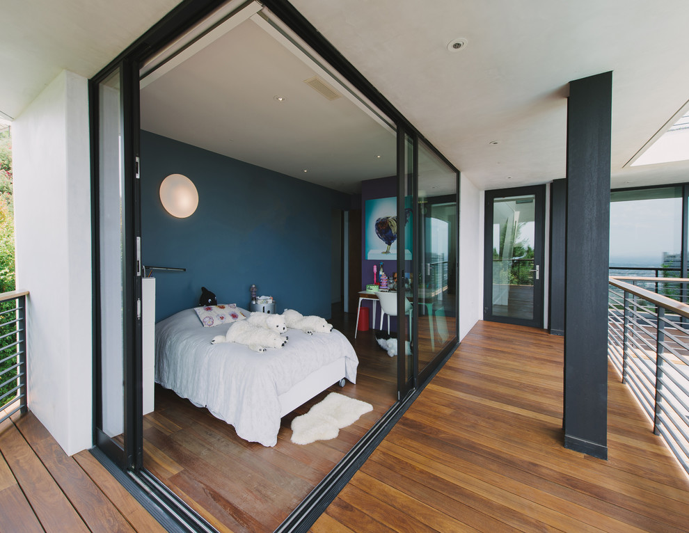 Modernes Mädchenzimmer mit Schlafplatz, blauer Wandfarbe und braunem Holzboden in Los Angeles
