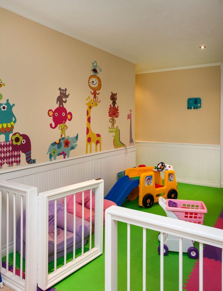 Exemple d'une grande chambre d'enfant de 1 à 3 ans tendance avec un mur jaune et moquette.