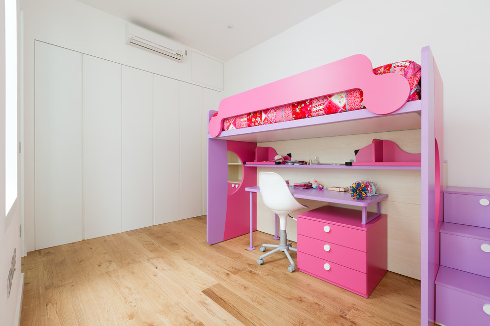 Cette photo montre une chambre d'enfant de 4 à 10 ans tendance de taille moyenne avec un mur blanc, un sol en bois brun, un sol marron et un lit superposé.