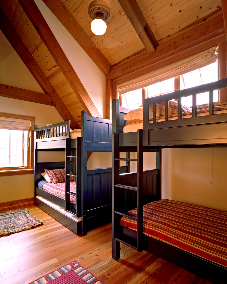 Bild på ett mellanstort lantligt könsneutralt barnrum kombinerat med sovrum, med gula väggar och mellanmörkt trägolv