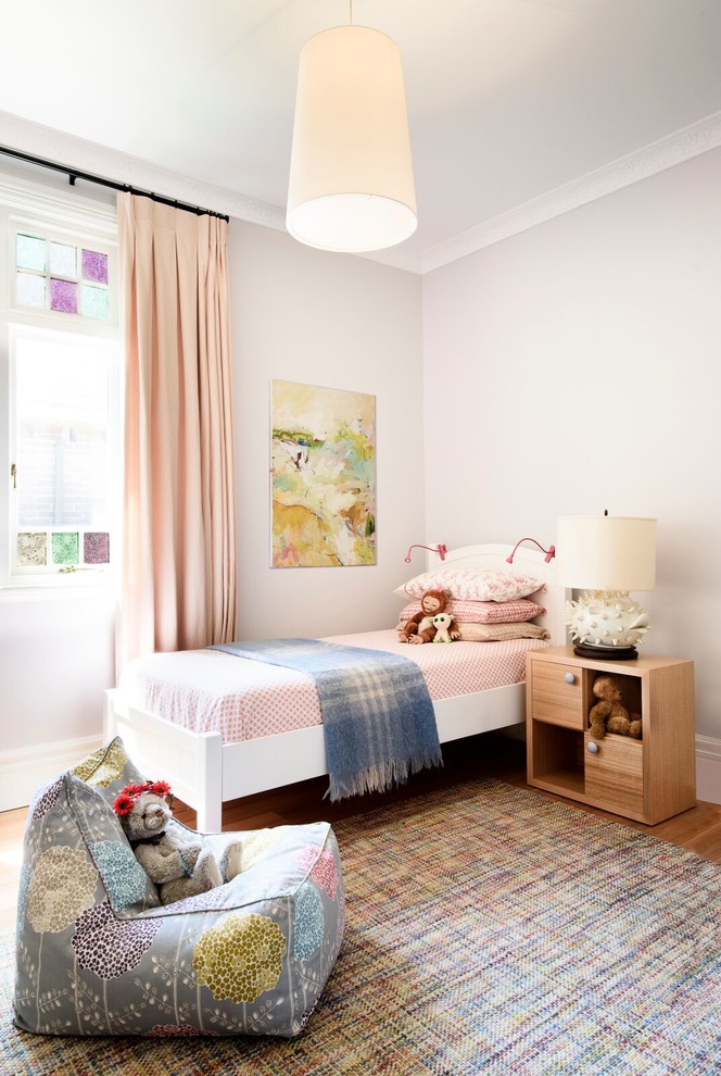 Immagine di una cameretta per bambini classica con pareti viola e parquet chiaro