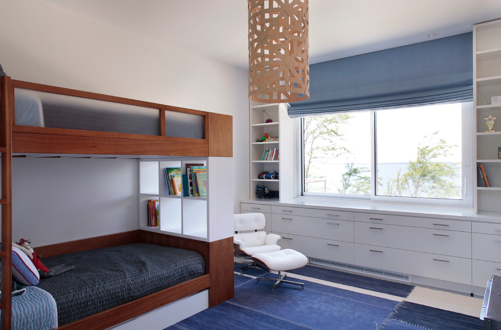 Modern inredning av ett mellanstort könsneutralt barnrum kombinerat med sovrum, med vita väggar och heltäckningsmatta