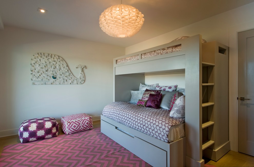 Photo of a nautical children’s room for girls in New York with beige walls and medium hardwood flooring.