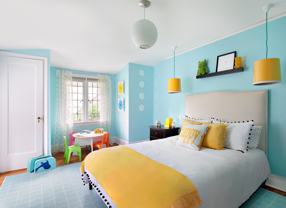 Esempio di una cameretta per bambini da 4 a 10 anni tradizionale con pareti blu, pavimento in legno massello medio e pavimento marrone