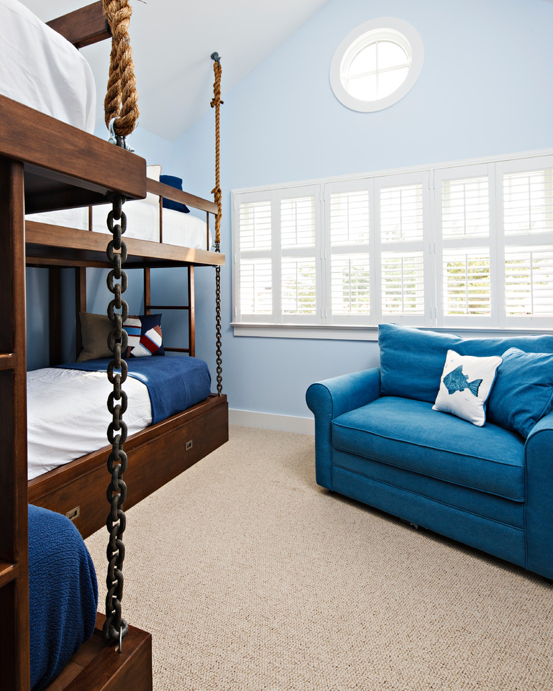Modelo de dormitorio infantil de 4 a 10 años costero de tamaño medio con paredes azules, moqueta y suelo beige