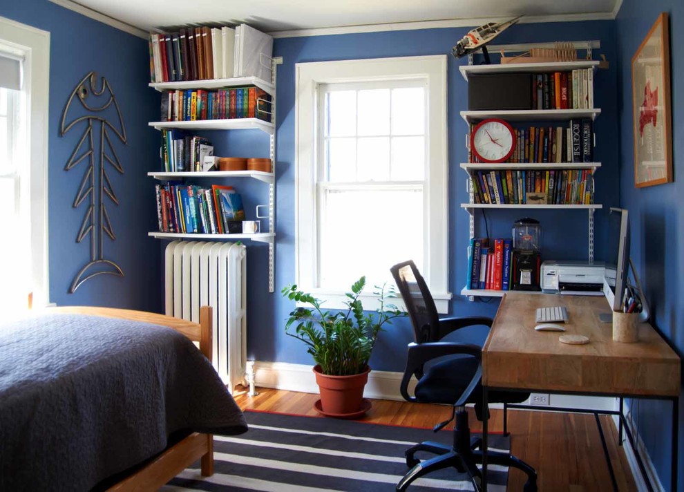 Cette photo montre une petite chambre d'enfant éclectique avec un mur bleu et parquet clair.