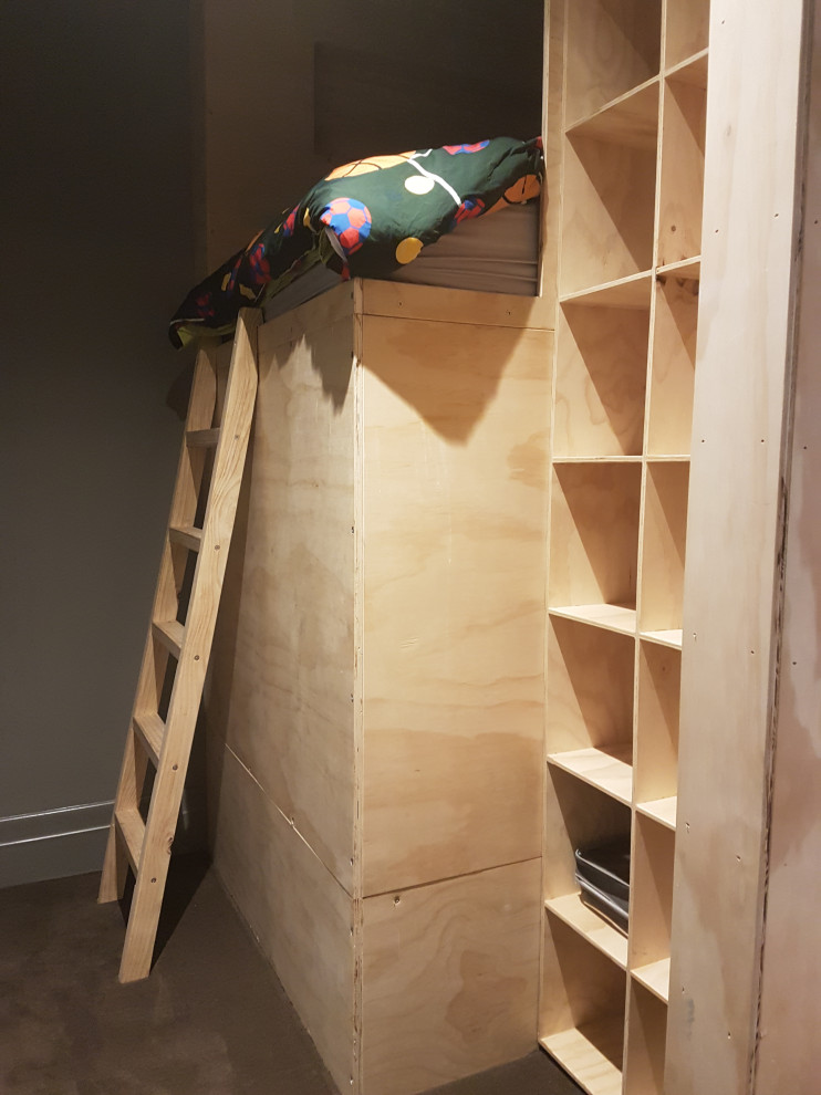 Large scandinavian gender neutral children’s room in Melbourne with brown walls, plywood flooring and brown floors.