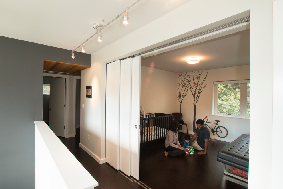 Inspiration pour une petite chambre d'enfant de 1 à 3 ans minimaliste avec parquet foncé et un mur gris.