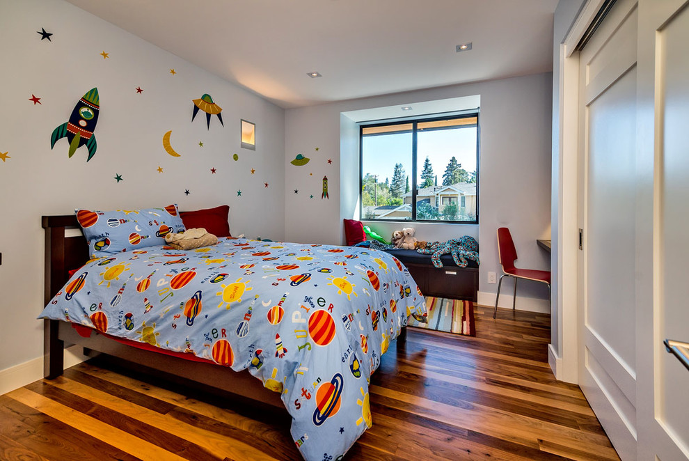 Exemple d'une chambre d'enfant tendance de taille moyenne avec un mur bleu et un sol en bois brun.