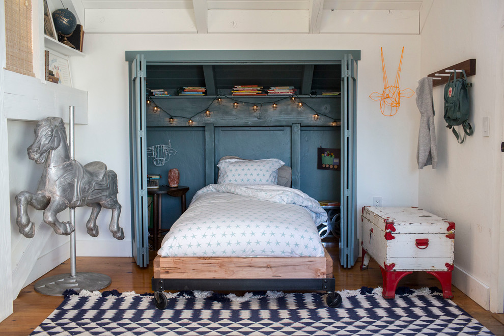 Modelo de dormitorio infantil de 4 a 10 años bohemio con paredes azules y suelo de madera oscura