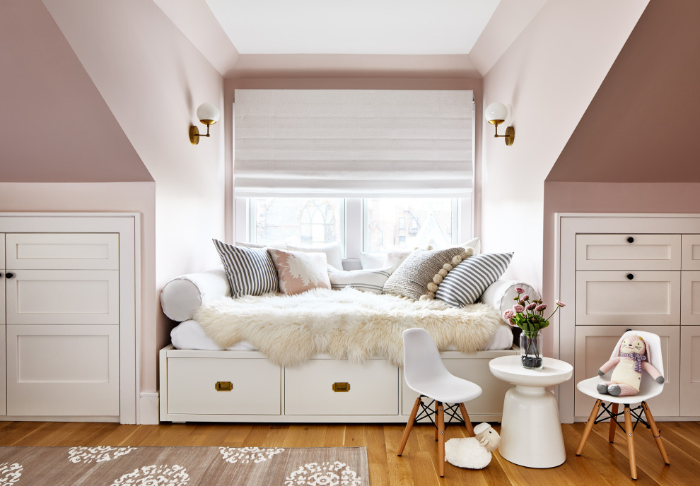 Inspiration for a large transitional girl medium tone wood floor and brown floor kids' room remodel in Los Angeles with pink walls