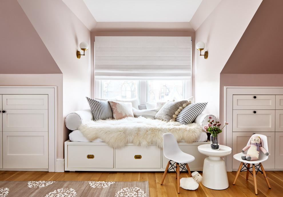 Klassisk inredning av ett stort barnrum kombinerat med sovrum, med rosa väggar, mellanmörkt trägolv och brunt golv
