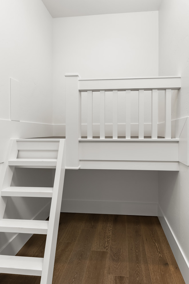 Ispirazione per una cameretta per bambini da 4 a 10 anni minimal di medie dimensioni con pareti bianche, pavimento in legno massello medio e pavimento marrone