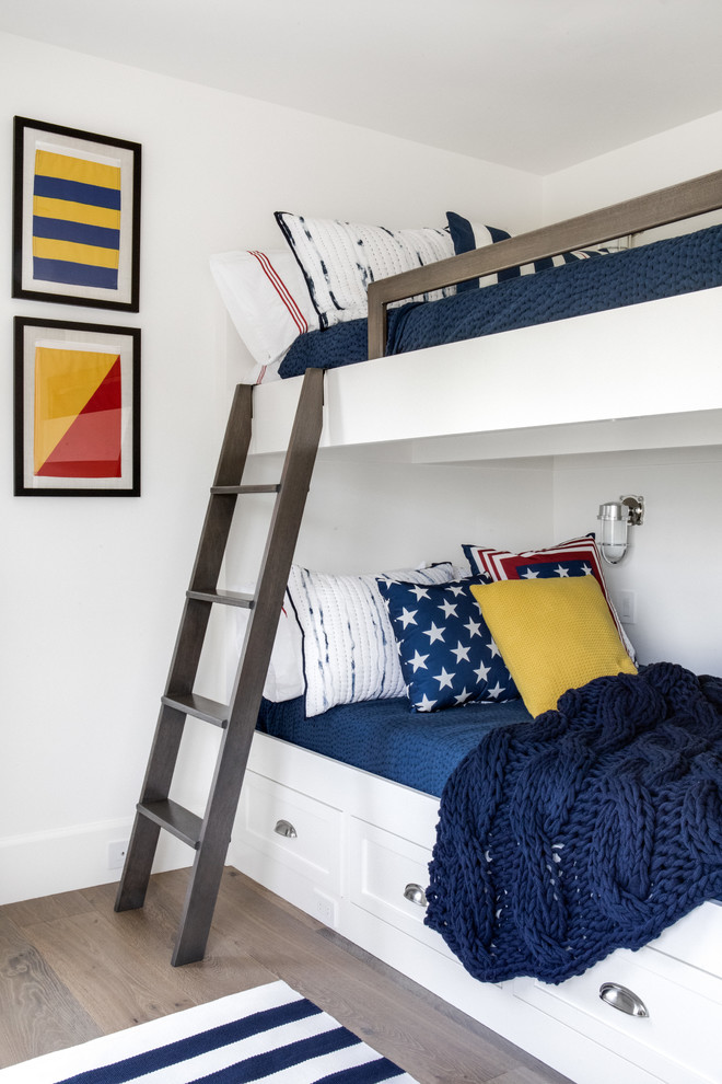 Diseño de dormitorio infantil marinero con paredes blancas y suelo de madera clara