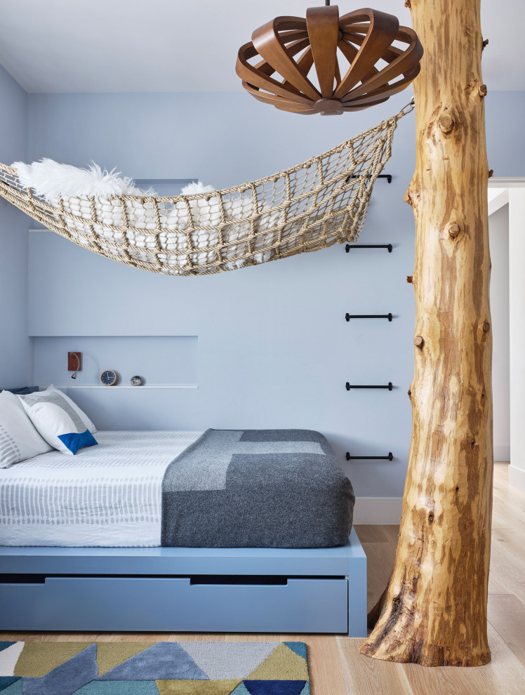 Modern inredning av ett pojkrum kombinerat med sovrum och för 4-10-åringar, med blå väggar, ljust trägolv och beiget golv