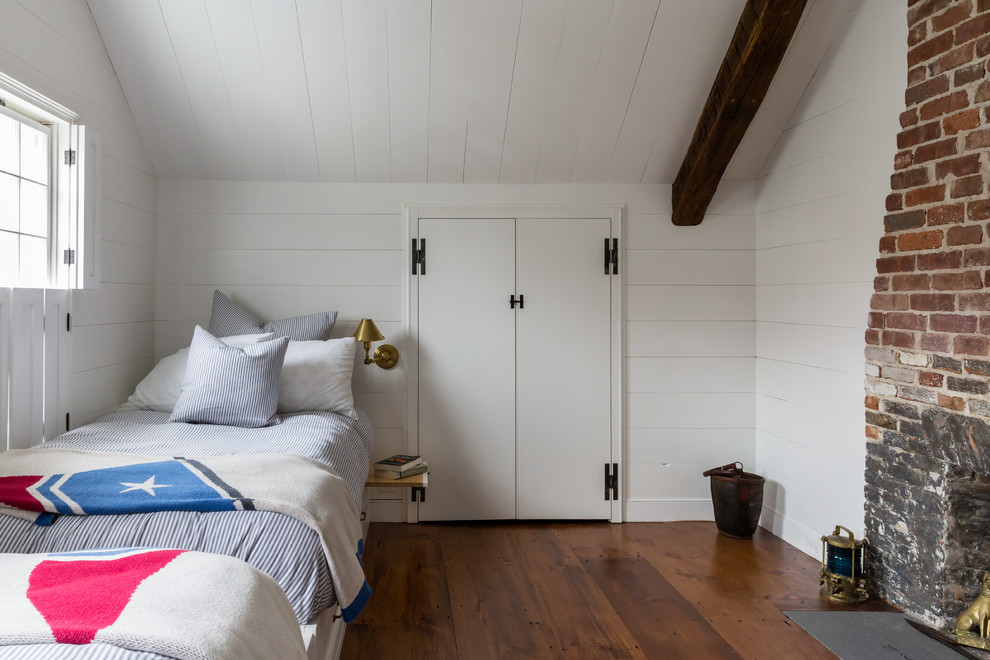 Modelo de dormitorio infantil de 4 a 10 años de estilo de casa de campo con paredes blancas, suelo de madera en tonos medios y suelo marrón