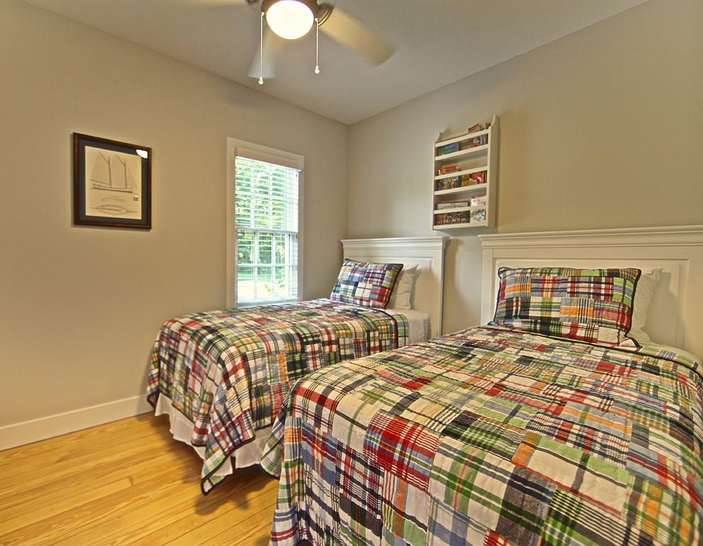 Photo of a small coastal gender neutral kids' bedroom in Grand Rapids with grey walls and light hardwood flooring.