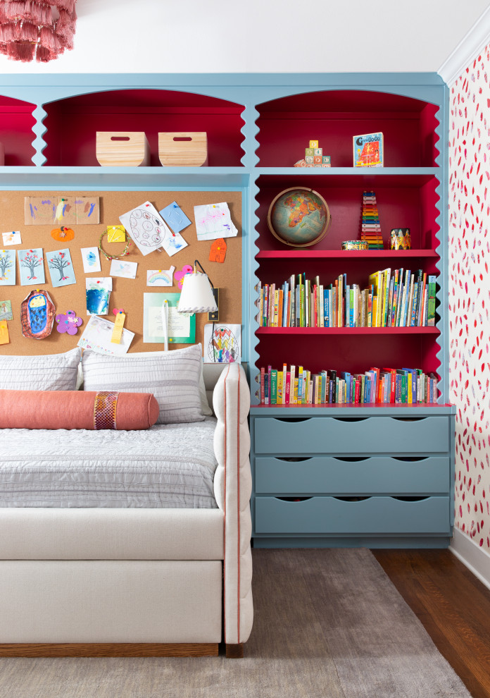 Immagine di una cameretta per bambini tradizionale di medie dimensioni con pareti rosse, pavimento in legno massello medio, pavimento marrone e carta da parati