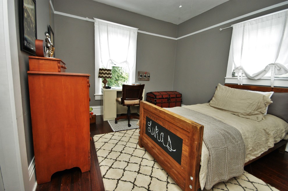 Lantlig inredning av ett mellanstort pojkrum kombinerat med sovrum och för 4-10-åringar, med grå väggar och mörkt trägolv