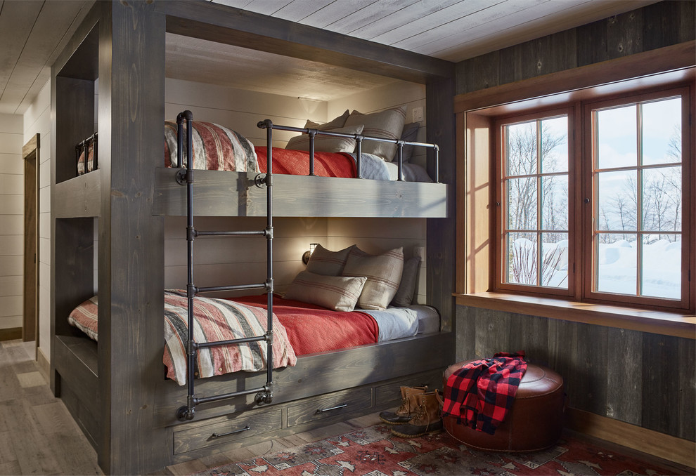 Cette image montre une chambre d'enfant chalet avec un mur blanc, un sol en bois brun, un sol marron et un lit superposé.
