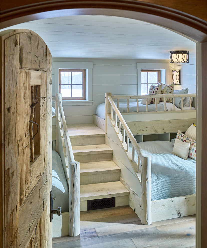 Imagen de dormitorio infantil rústico con paredes blancas, suelo de madera clara y suelo beige