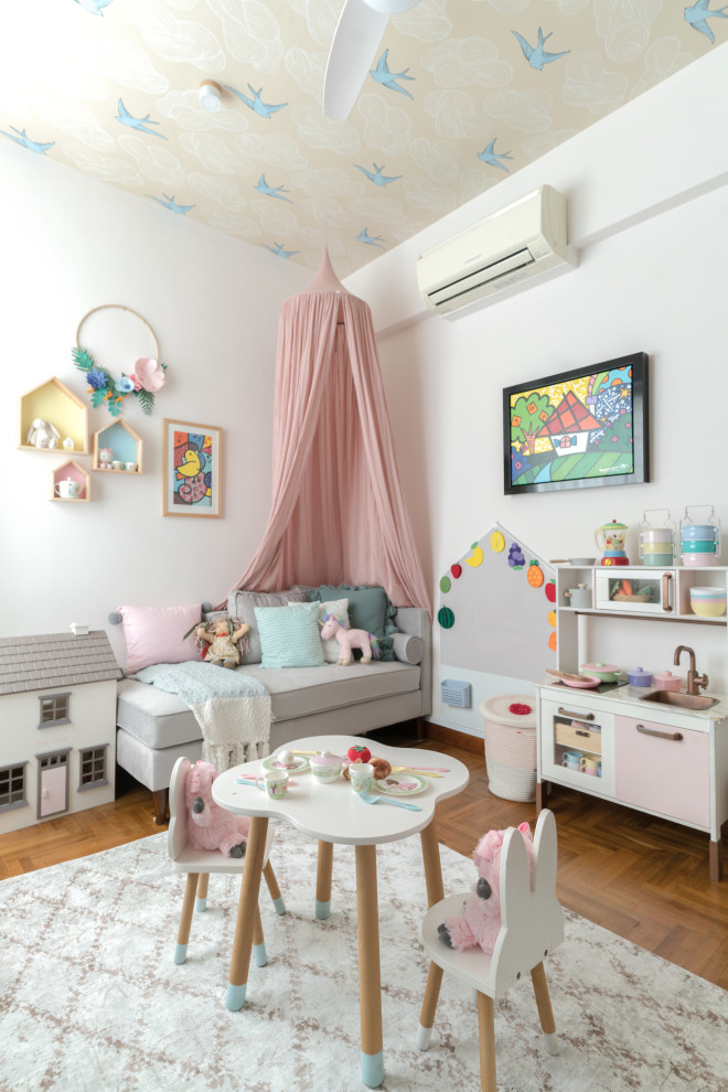 Inredning av ett modernt barnrum kombinerat med lekrum, med vita väggar, mellanmörkt trägolv och brunt golv