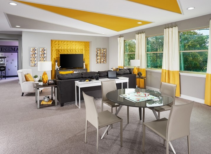 Exempel på ett stort modernt könsneutralt tonårsrum kombinerat med lekrum, med gula väggar, heltäckningsmatta och grått golv