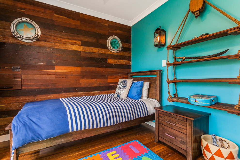 Пример оригинального дизайна: детская в морском стиле с спальным местом, синими стенами и паркетным полом среднего тона для ребенка от 4 до 10 лет, мальчика