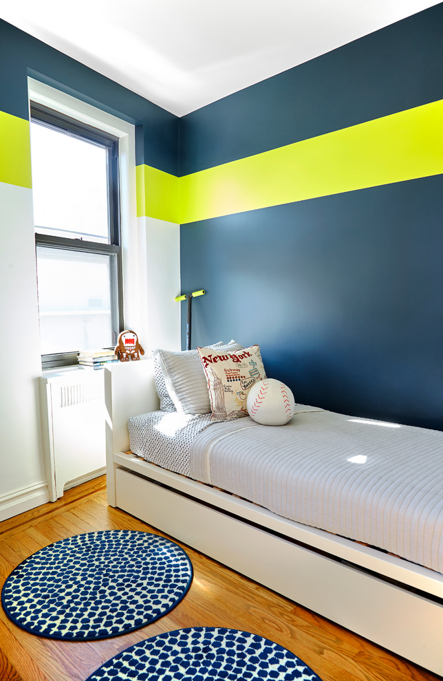 Aménagement d'une petite chambre d'enfant de 4 à 10 ans contemporaine avec un sol en bois brun et un mur multicolore.