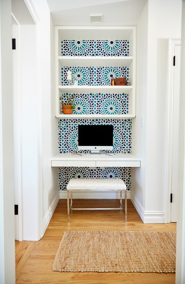 Idée de décoration pour une petite chambre neutre design avec un mur bleu, un sol en bois brun et un bureau.